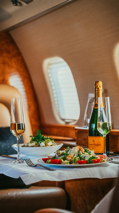 Champagne and gourmet catering service during private jet flight